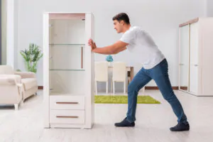 man moving the furniture for painting